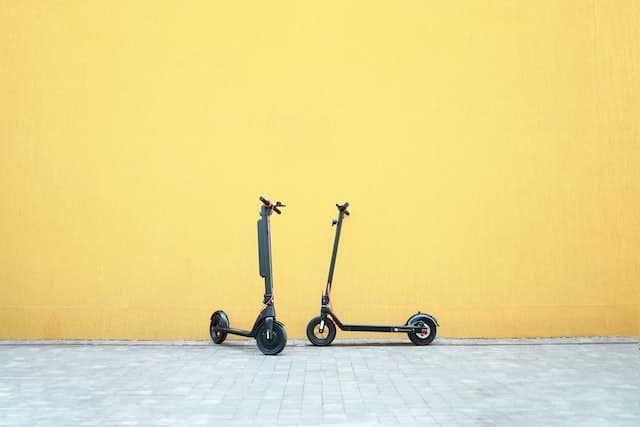 scooter op gele muur Laadstation voor elektrische scooters